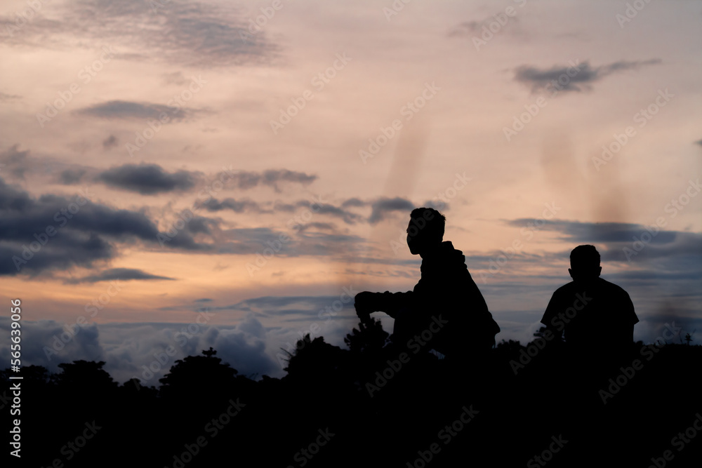 Silhouette photo of two men in the evening.