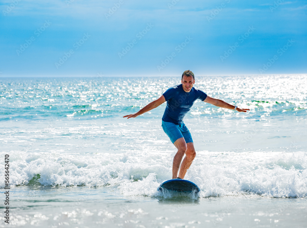 Man learns to surf waves balancing on surfboard