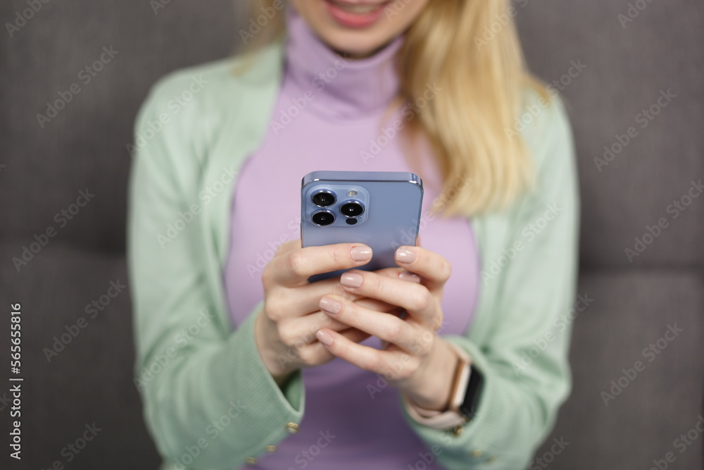 Blonde woman typing message on social media app in smart phone. Close up photo of adult female person using mobile phone Blonde woman typing message on social media app in smart phone. Close up photo of adult female person using mobile phone