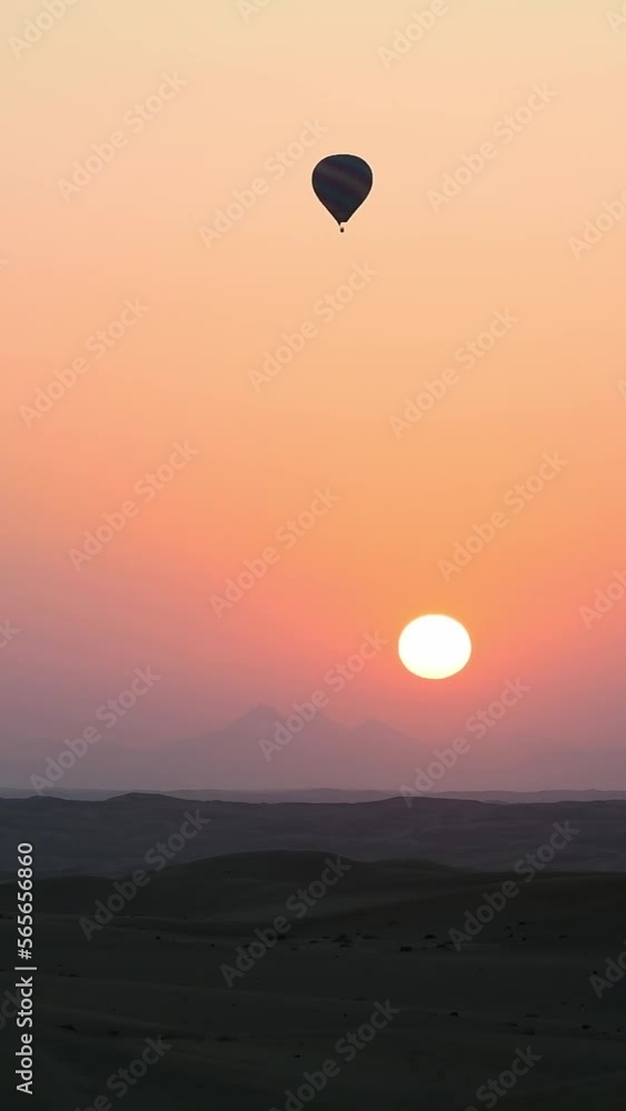 Hot air balloon flying above the desert at sunrise, vertical video perfect for immersive viewing on portable devices Hot air balloon flying above the desert at sunrise, vertical video perfect for immersive viewing on portable devices