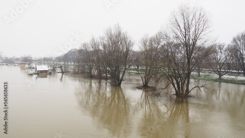 Macvanska Mitrovica, Serbia, 01/27/2023 The bridge over the Sava River. Flooding after heavy rains and snowmelt. A swift flow of muddy water. Trees, boats and piers in the water. Machva in winter. © Iuliia