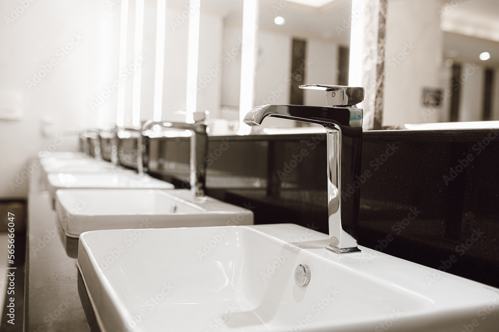 Empty washing hand sinks in public bathroom interior. Healthcare and Hygiene. Public toilets concept. Empty washing hand sinks in public bathroom interior. Healthcare and Hygiene. Public toilets concept.