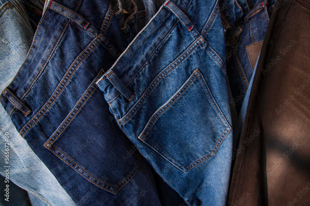 Fototapeta premium Jeans hanging on a rack in a store, close-up