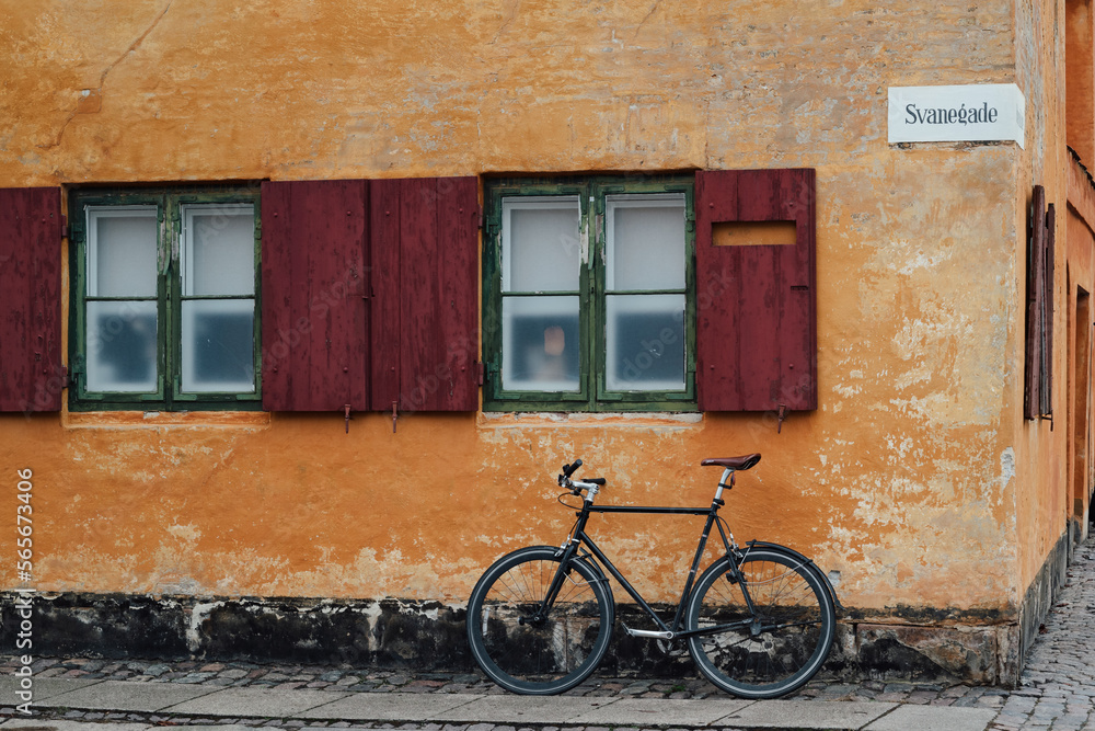 bicycle in front of a house with an orange wall in copenhagen, denmark
