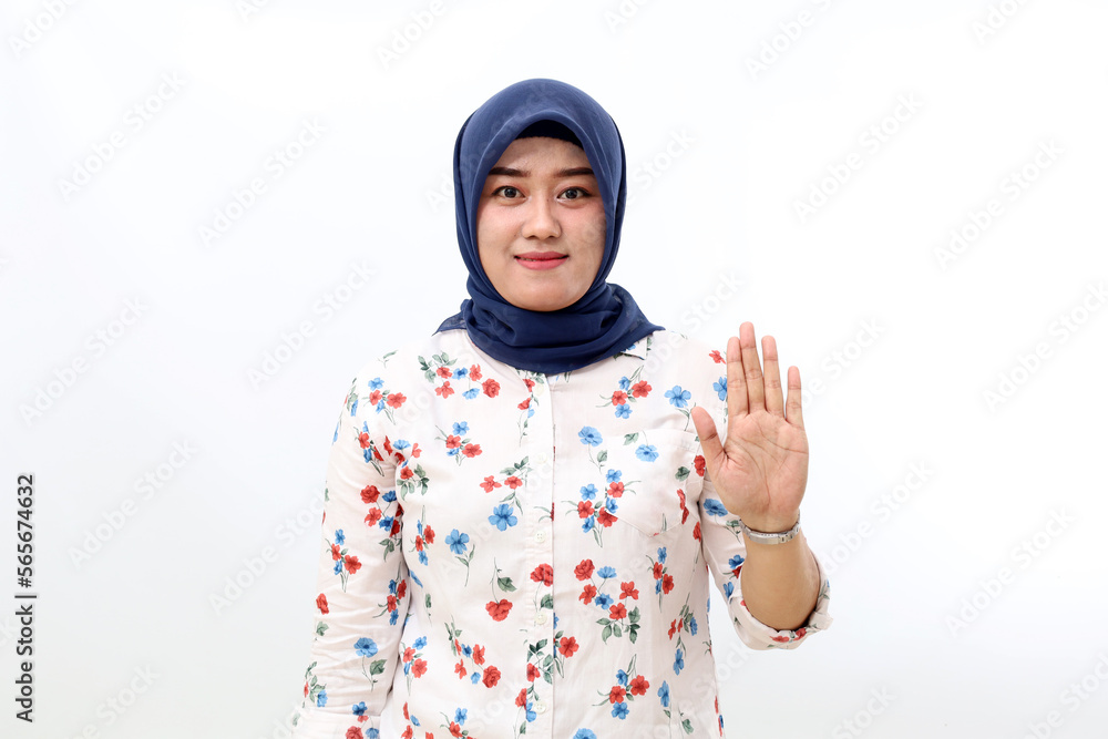Happy asian muslim woman standing with stop hand gesture. Isolated on white background