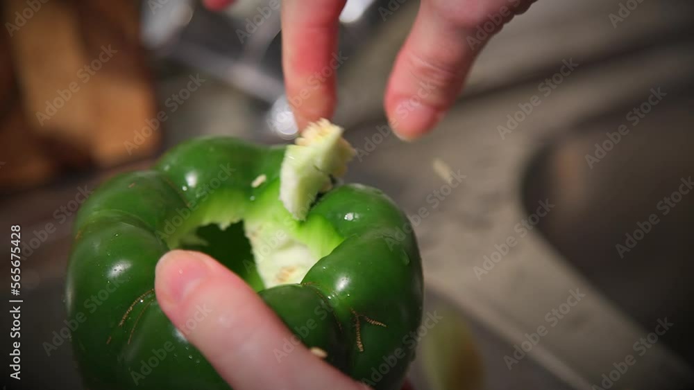 cleaning a green bell pepper from seeds and preparing to use for a stuffed peppers recipe Stock
