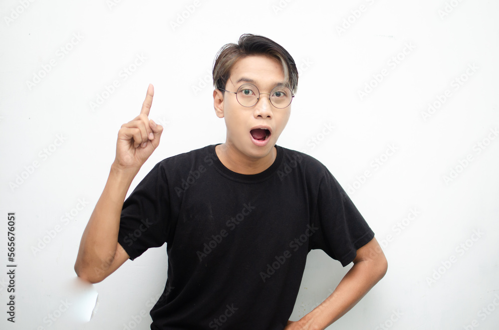 A cheerful, ecstatic Asian man wears a casual black t-shirt, pointing to copy space and presenting and displaying goods. billboard model advertisment concept. A man with a wow expression displaying so A cheerful, ecstatic Asian man wears a casual black t-shirt, pointing to copy space and presenting and displaying goods. billboard model advertisment concept. A man with a wow expression displaying so
