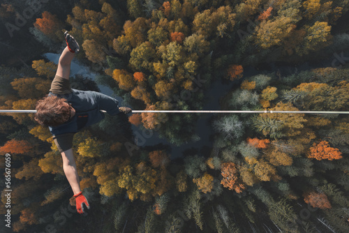 Highline over the forest. Rope walker walks on a rope at high altitude. Drone view. Slackline theme photo
