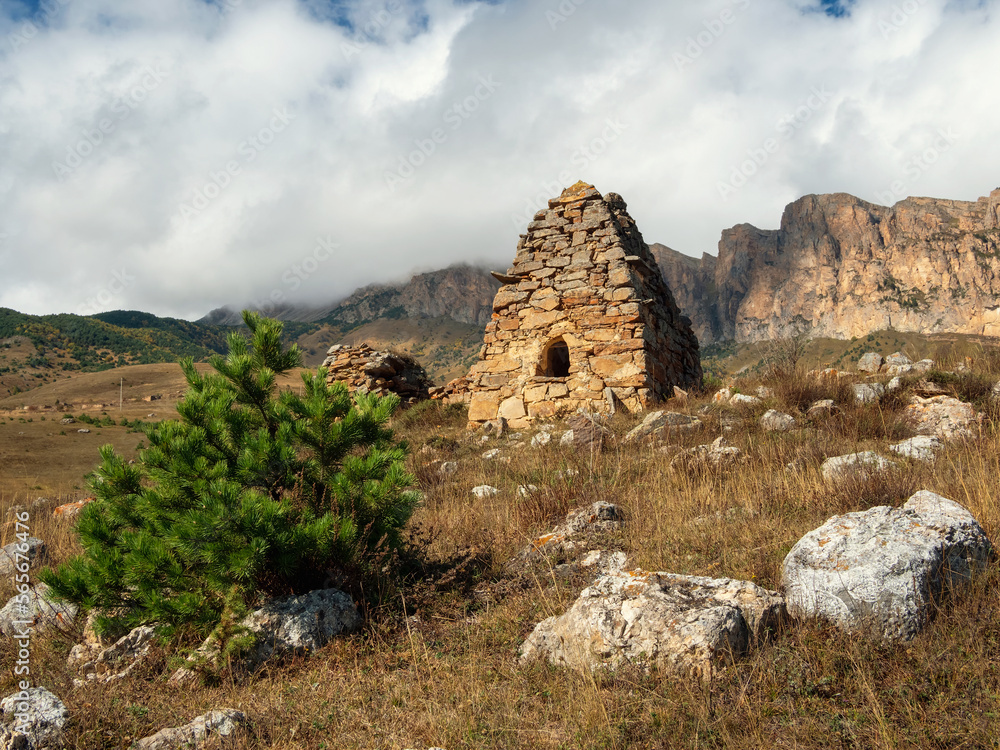Old stone tomb, a crypt on the top of a mountain. Old Ossetian family crypt in the misty mountains. Russia.