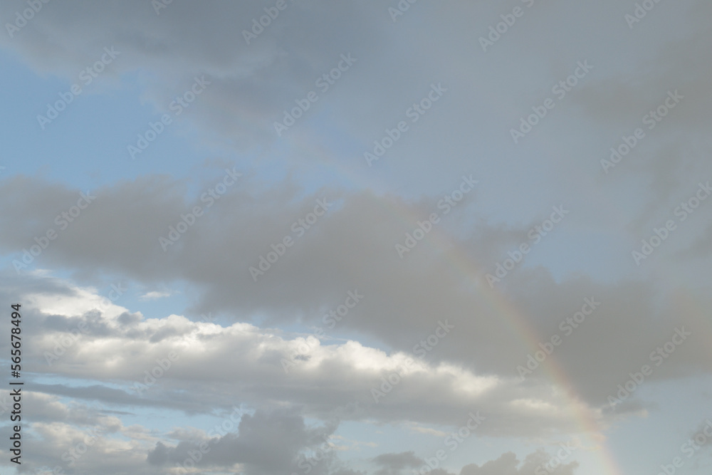 Sky with giants cumulonimbus clouds and rainbow in summer