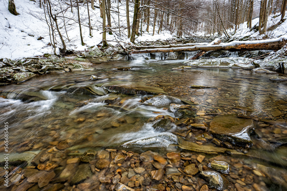 Mountain stream in winter scenery. Prowcza Stream, Bieszczady National Park, Carpathian Mountains, Poland. One of the most popular travel destinations in Poland. Mountain stream in winter scenery. Prowcza Stream, Bieszczady National Park, Carpathian Mountains, Poland. One of the most popular travel destinations in Poland.