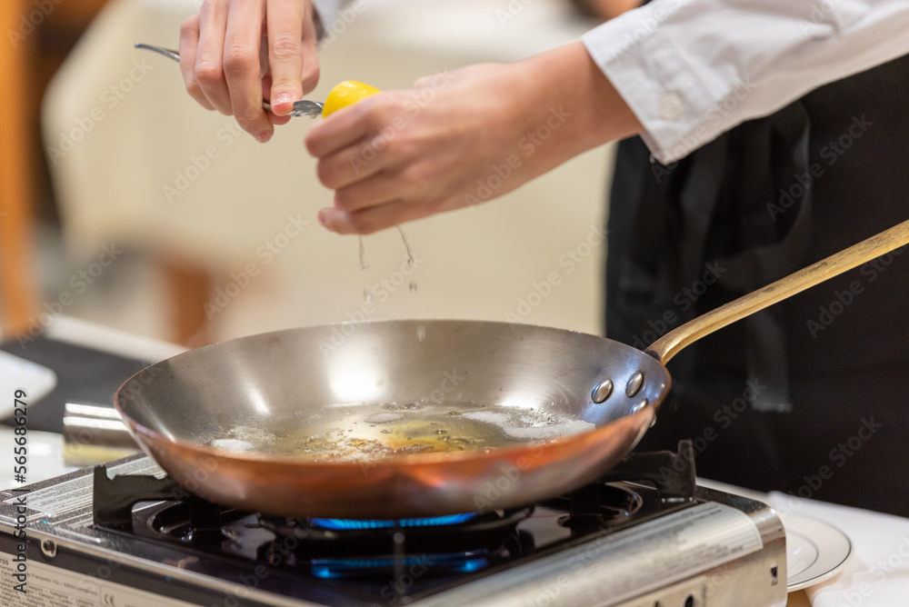 Citron pressé versé sur une préparation de flambage dans un restaurant Citron pressé versé sur une préparation de flambage dans un restaurant