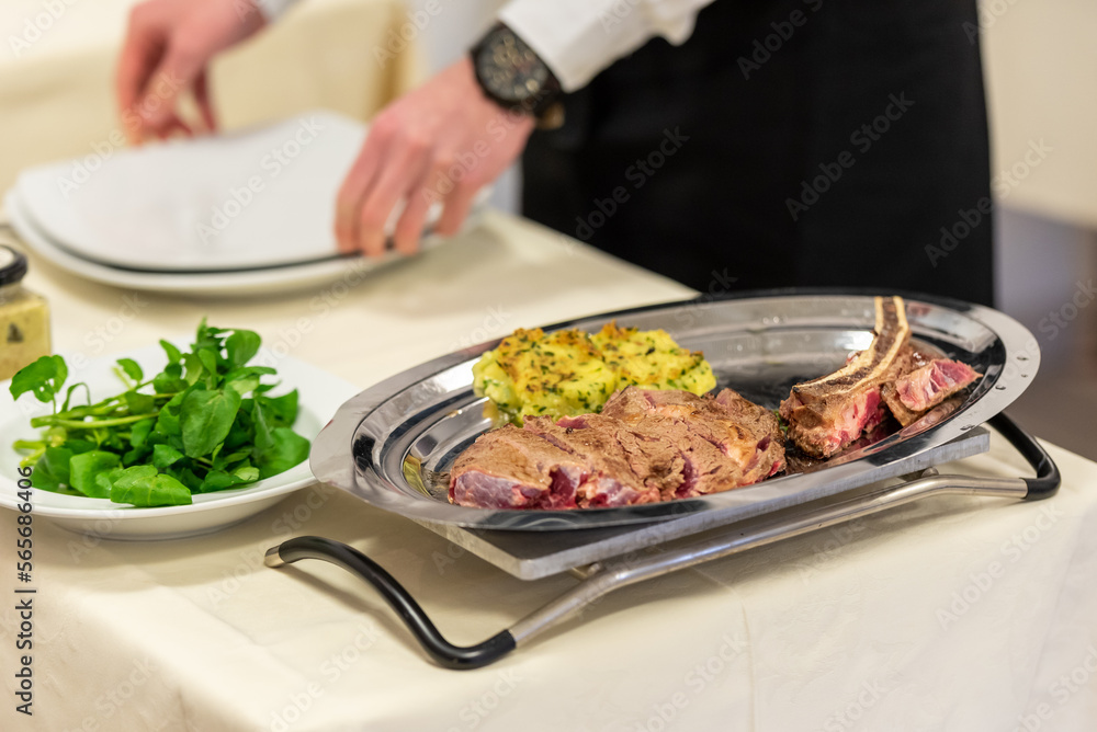 Service d'une pièce de viande de boeuf en restaurant Service d'une pièce de viande de boeuf en restaurant