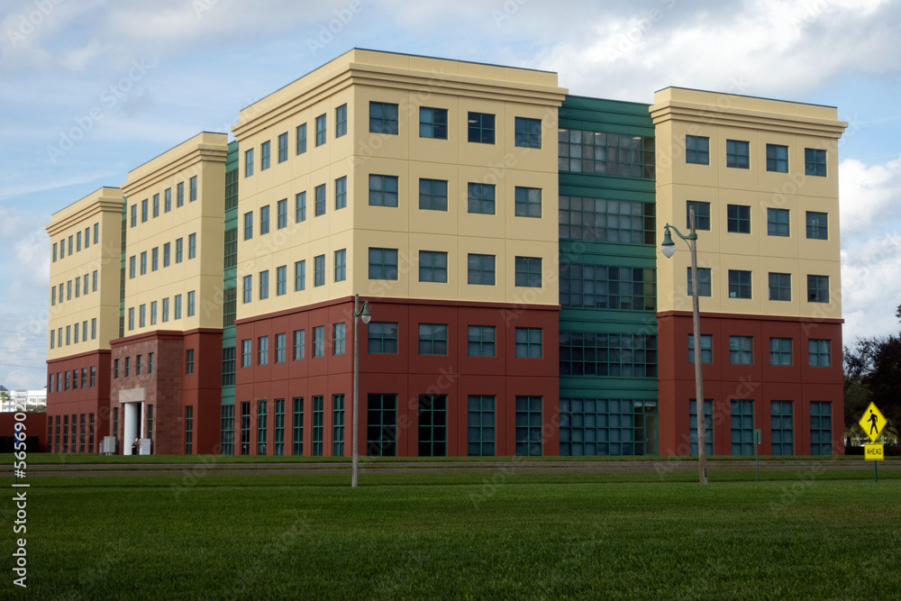 Brand new yellow, red, and green office building with a manicured, green grass lawn