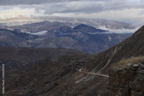 Scenic panorama: foggy mountains, cloudy sky and undulating slopes on a winter day in Dagestan.
