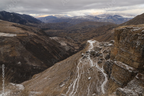 Scenic panorama: foggy mountains, cloudy sky and undulating slopes on a winter day in Dagestan.