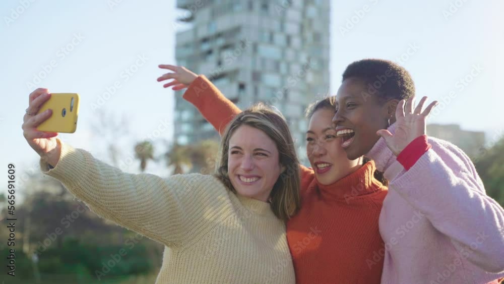 Three diverse girls taking a selfie portrait with smartphone. An Asian Chinese woman, a black African and a Caucasian lady together and embracing. Friendship multi-ethnic group of real people. Three diverse girls taking a selfie portrait with smartphone. An Asian Chinese woman, a black African and a Caucasian lady together and embracing. Friendship multi-ethnic group of real people.