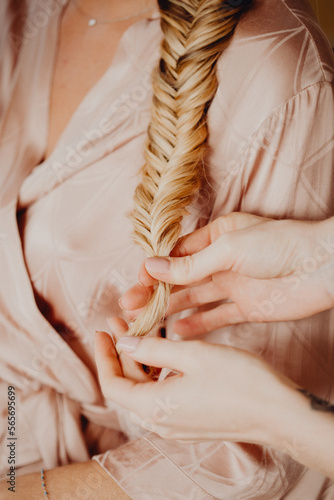Fotografia, Obraz Femme blonde se faisant coiffer avec une tresse