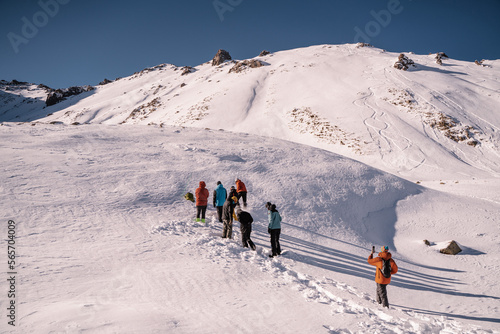 a small group of people climb a snowy slope