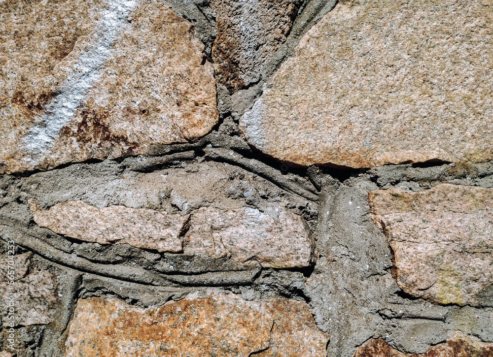 Fototapeta premium The masonry wall is made of large natural granite blocks.