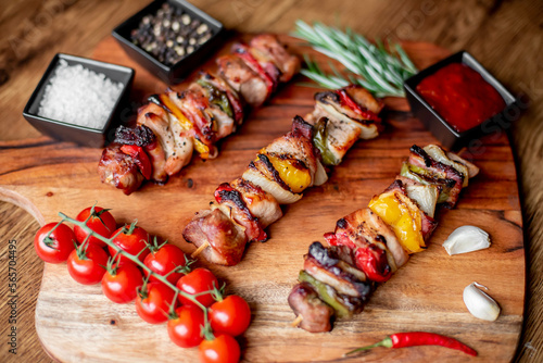 Meat kebabs with grilled vegetables on a rustic background