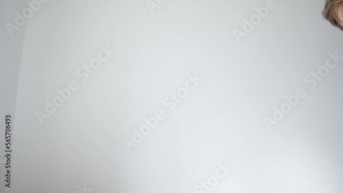 The young man looks into the laptop screen. View from the laptop webcam. An empty frame, a view of a white wall. The human head appears on the top right. High quality 4k footage