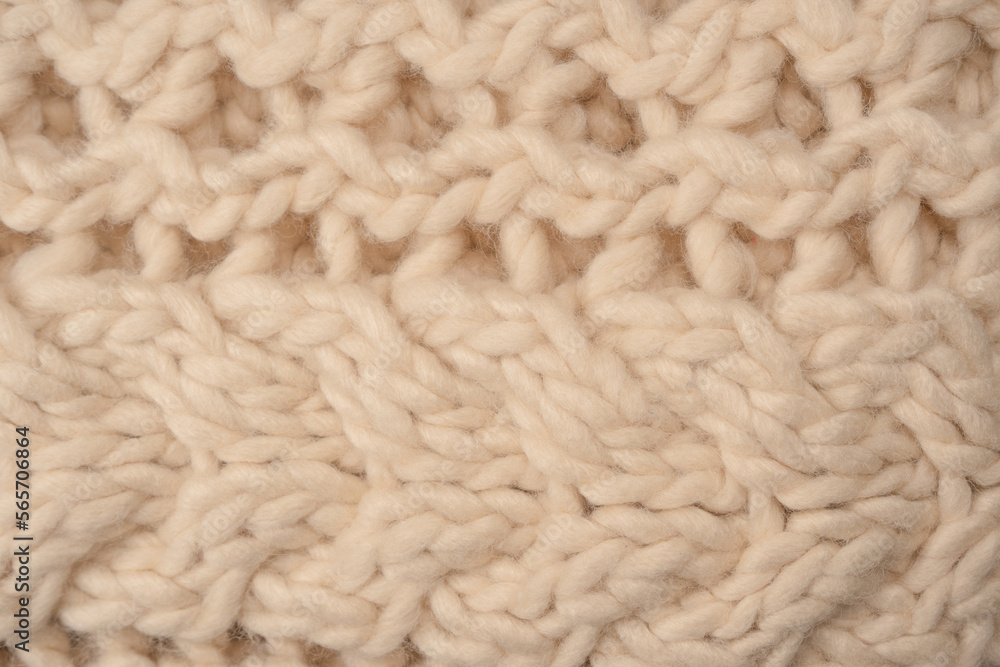A fragment of beige knitted fabric, knitted from white sheep wool. A fragment of beige knitted fabric, knitted from white sheep wool.