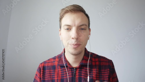 An employee listens to an online presentation via video communication, the call ends, the man says goodbye to colleagues, takes off his wired headphones and leaves the workplace.