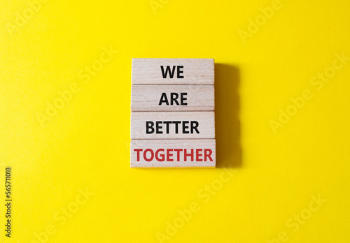 We are stronger together symbol. Wooden blocks with words We are stronger together. Beautiful yellow background. We are stronger together concept. Copy space. photo