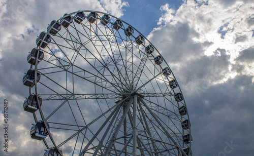 A new metal Ferris wheel with booths on the background of a blue cloudy sky in Vladimir Park Russia on a summer day and a space for copying