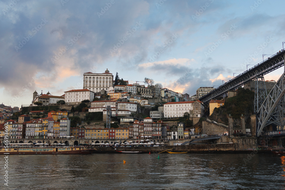 Historic centre, Porto, Portugal - center of town and city. Douro river, embankment and waterfront, building and houses and histrocial landmarks and monuments. Evening before dusk, cloudy sky.