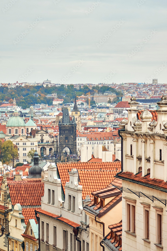 Facades of old buildings with tile roofs in downtown of Prague. Cityscape on the horizon.