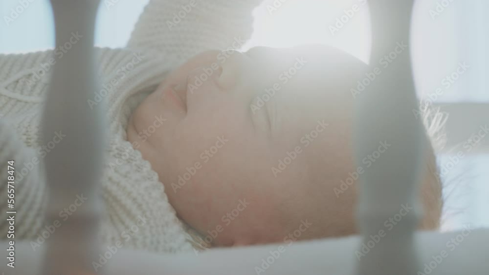 Cute lovable newborn baby smiling while lying in the wooden cradle, moving hands and looking around in slow-motion Cute lovable newborn baby smiling while lying in the wooden cradle, moving hands and looking around in slow-motion