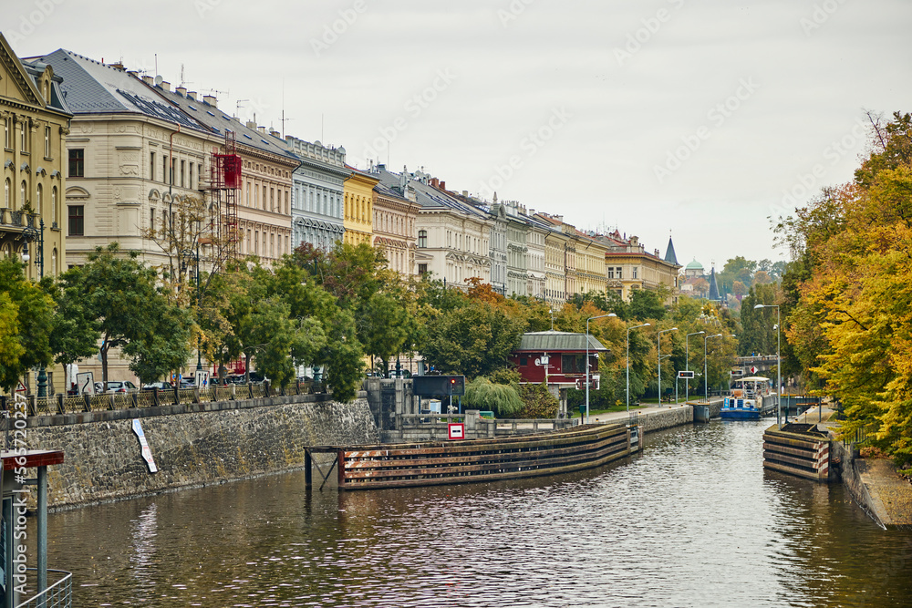 Naklejka premium Historic buildings on the banks of the water canal in Prague in autumn.