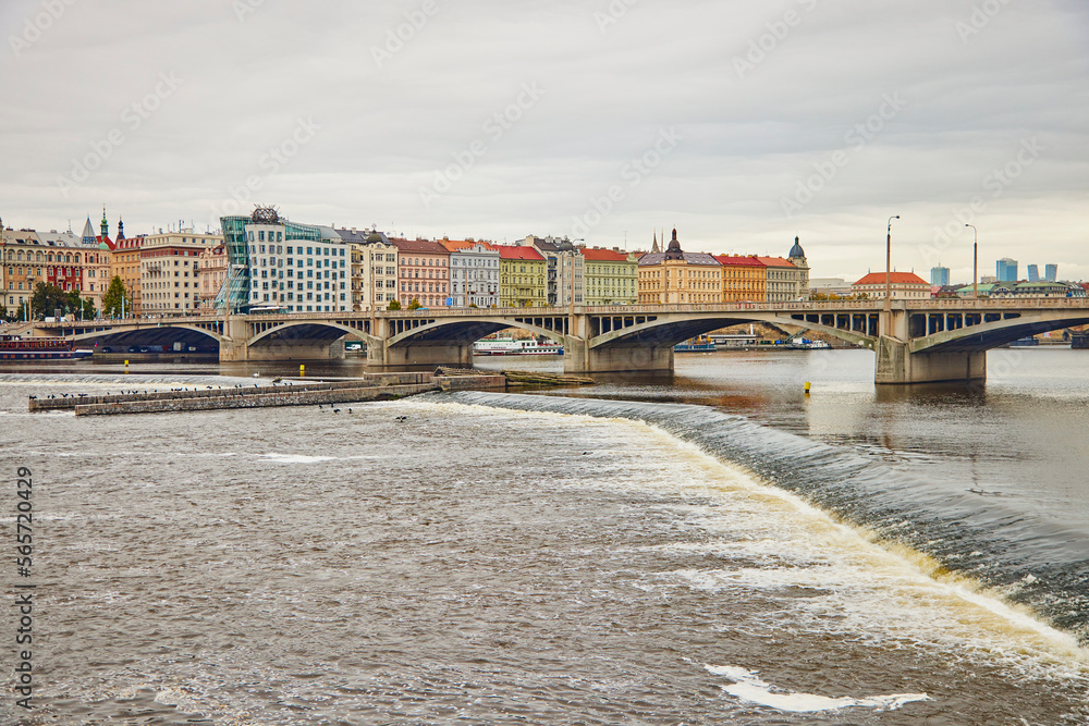View of Jirasek Bridge under the Vltava river and colorful historical buildings in Prague.