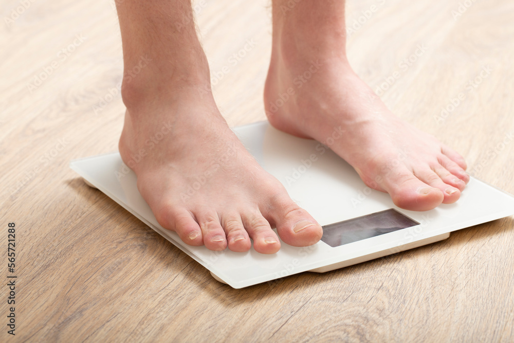 A man stands on the scales.Diet, weight loss concept. A man stands on the scales.Diet, weight loss concept.