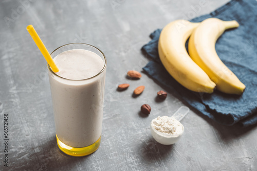 Banana smoothie with protein powder and nuts in a glass, healthy eating concept