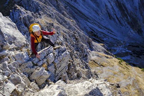 Mann beim Bergsteigen gibt ok mit Daumen hoch