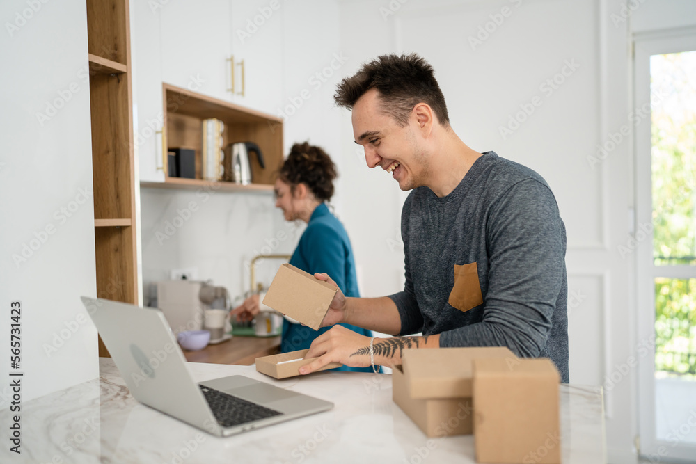 Fototapeta premium couple woman and man open presents gift in front of laptop computer
