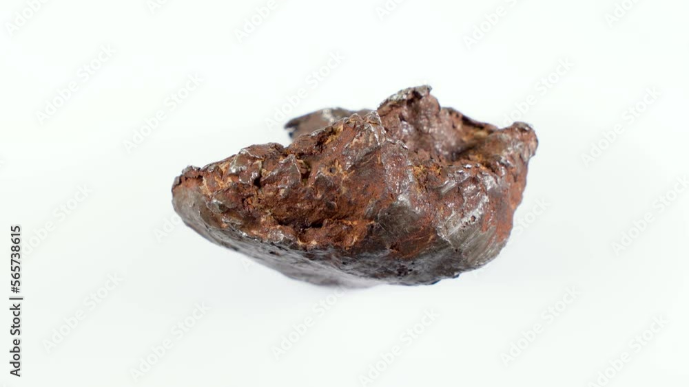 Rotating Of An Iron Meteorite. White background on a white base. general plan. Rust on the surface Rotating Of An Iron Meteorite. White background on a white base. general plan. Rust on the surface
