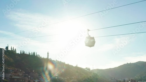 Cable car trip. During the trip by cable car Tourists enjoy beautiful views and experience exciting. Aerial view of Georgia, Tbilisi, Peace Bridge, Concert Music Theatre, river Kura and Cable car.