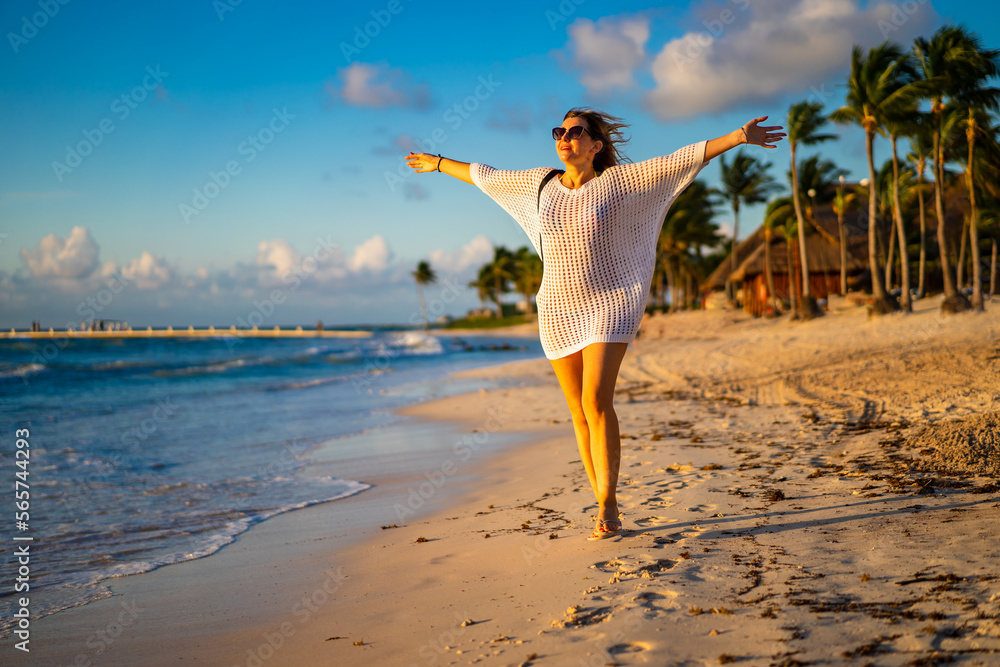 Beach holiday - woman walking on sunny, tropical beach in the morning
Beach holiday - woman walking on sunny, tropical beach in the morning