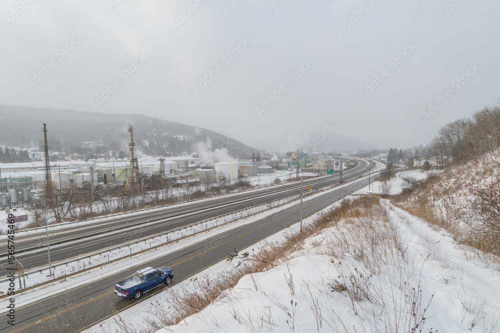 Obraz premium Mountain town highway road and oil plant during snow weather, travel USA town