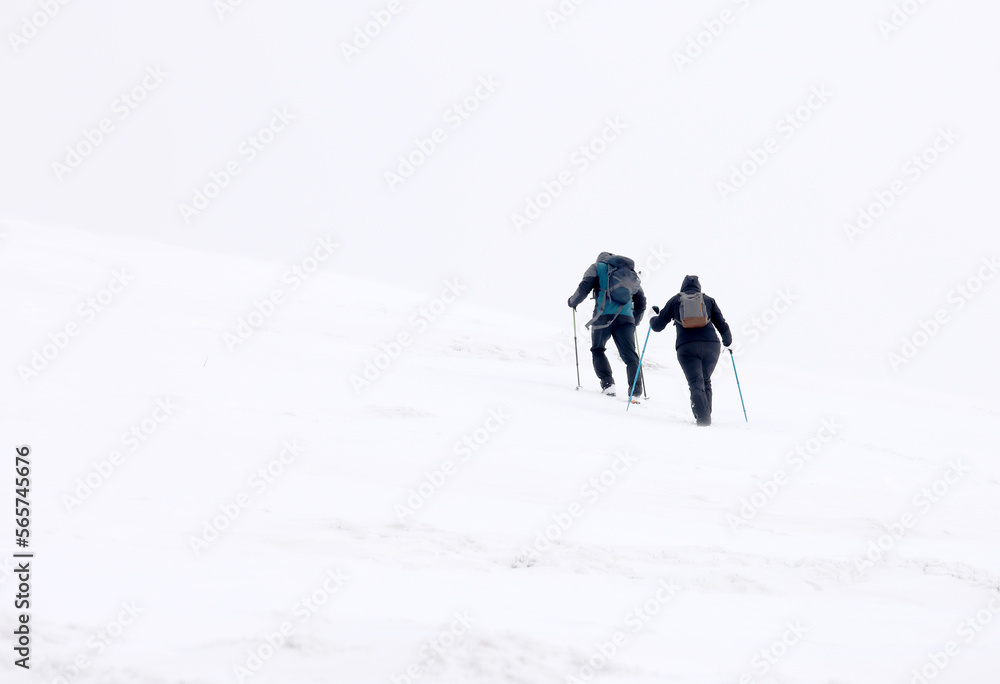 Winter mountain climbing in harsh blizzard conditions, Parng Mountains, Romania, Europe	