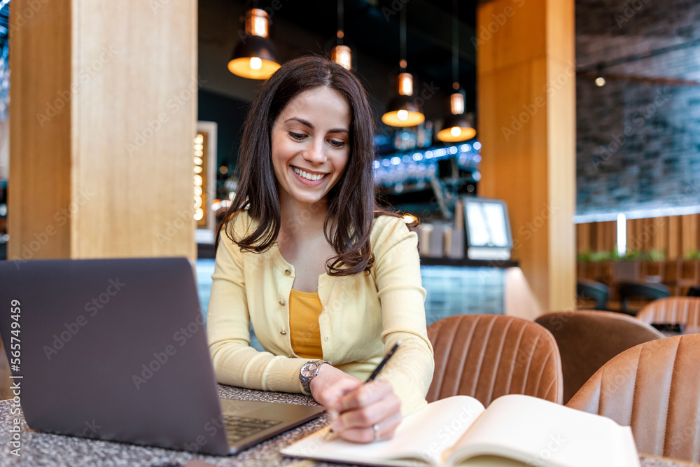 Young businesswoman using laptop while working in a modern coffee shop Young businesswoman using laptop while working in a modern coffee shop