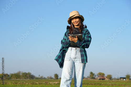 Asian female farmers use computers to analyze the growth of rice plants.