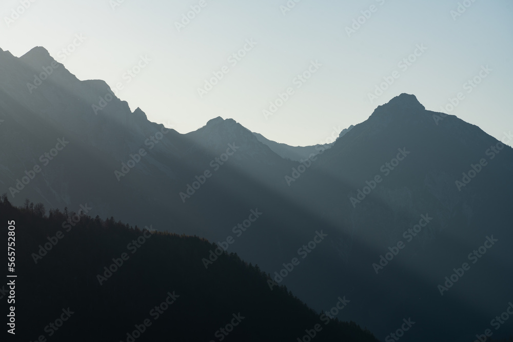 Sun pouring through mountain silhouette 