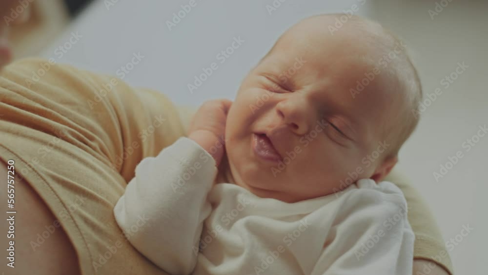 Close-up view of a happy mother holding her newborn baby in her arms. Baby sleeping peacefully in mother's hands. Slow-motion shot Close-up view of a happy mother holding her newborn baby in her arms. Baby sleeping peacefully in mother's hands. Slow-motion shot