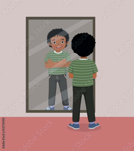happy little African boy standing in front of mirror looking his reflection with arm crossed pose
