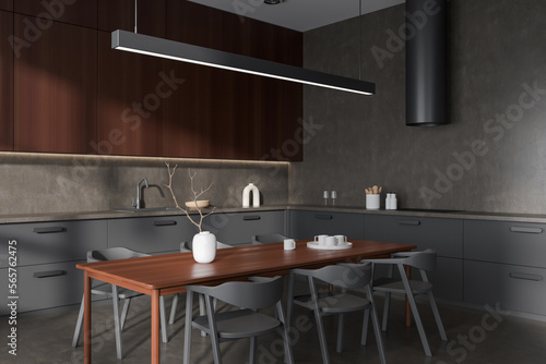 Modern kitchen interior with seats and eating table on grey concrete floor